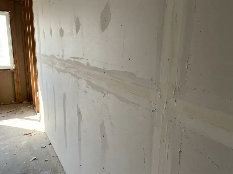 Gipskartonwand met afgewerkte voegen en wapeningsband, klaar voor de laatste laag voegmiddel